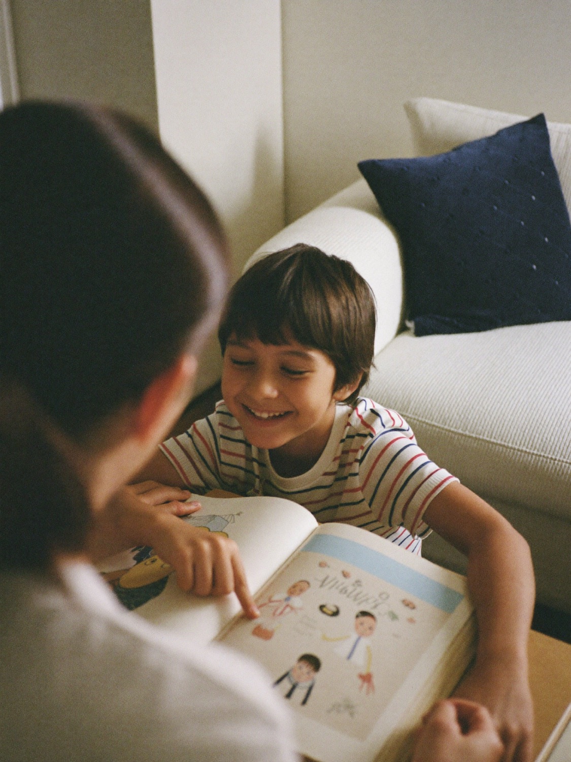 A primary school student reading with a tutor