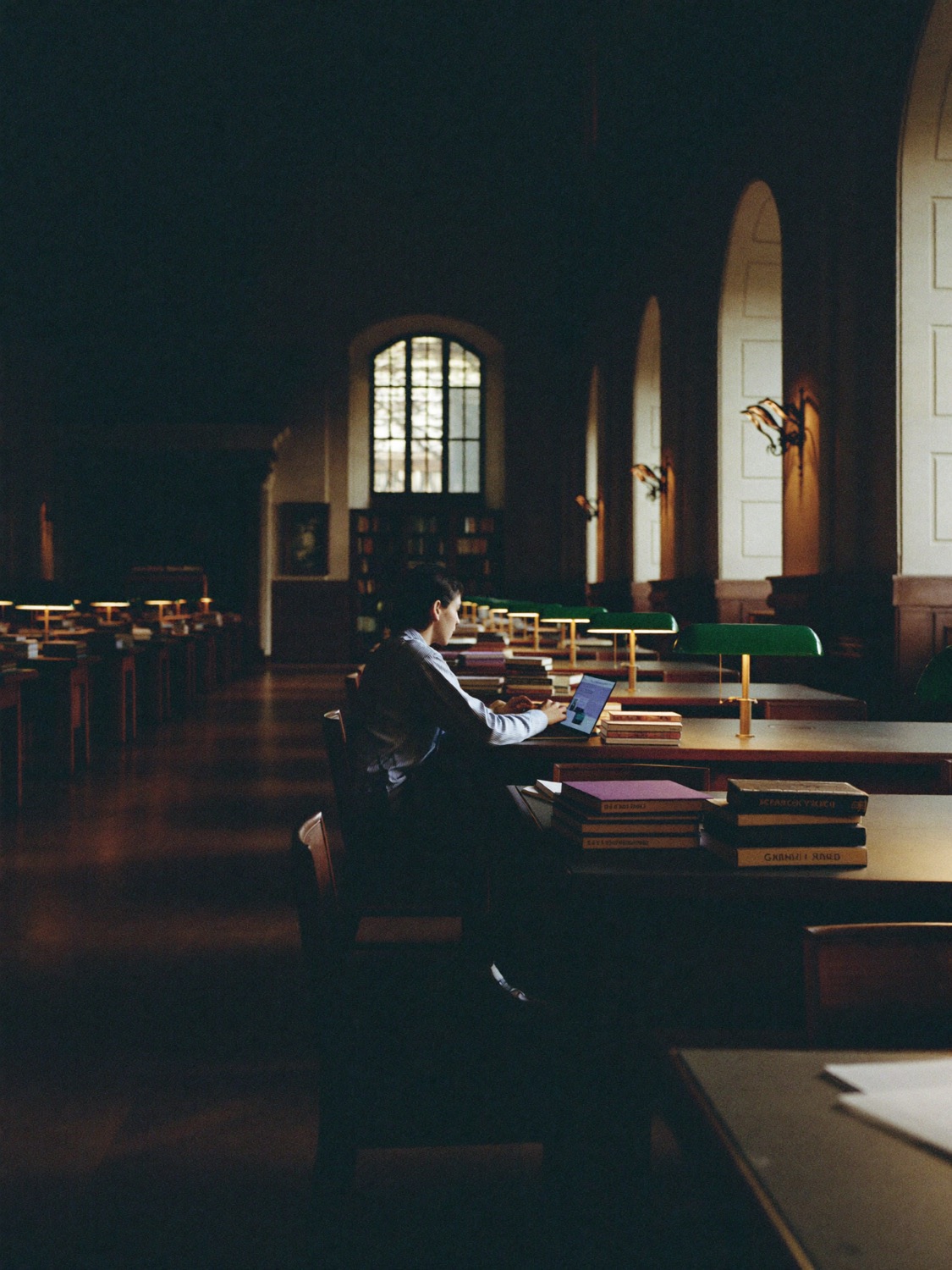 A university student studying in a heritage library reading room